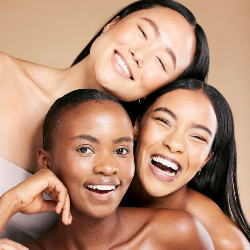 3 women of different skin tones smiling